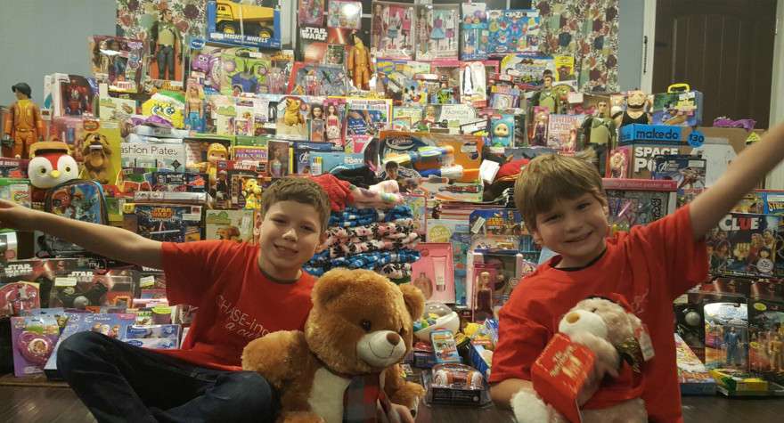 Chase and Travis Kemberling pose in front of their 2016 toy donations for CHASE-ing A Cure.